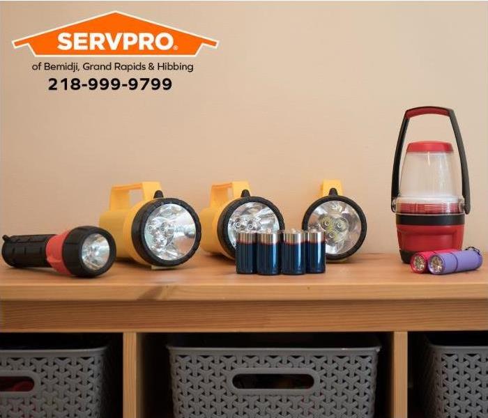 Flashlights and batteries sit on a counter in a home, ready for emergency use.