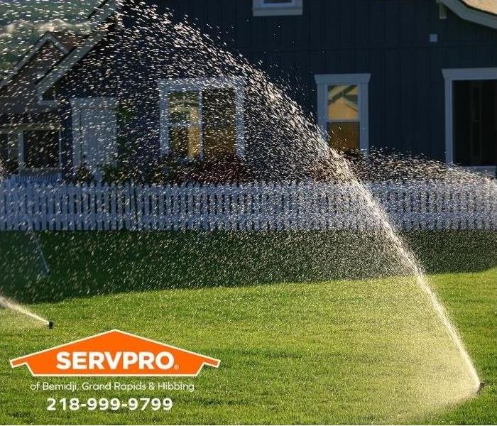 Sprinklers water a lawn.