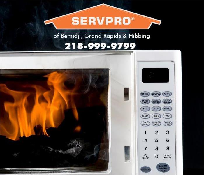 A microwave oven is shown with flames coming out of the oven compartment.